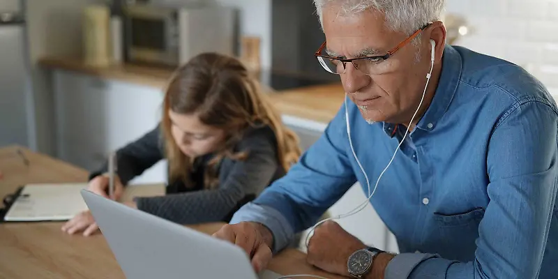 Vater und Tochter hören im Homeoffice Musik