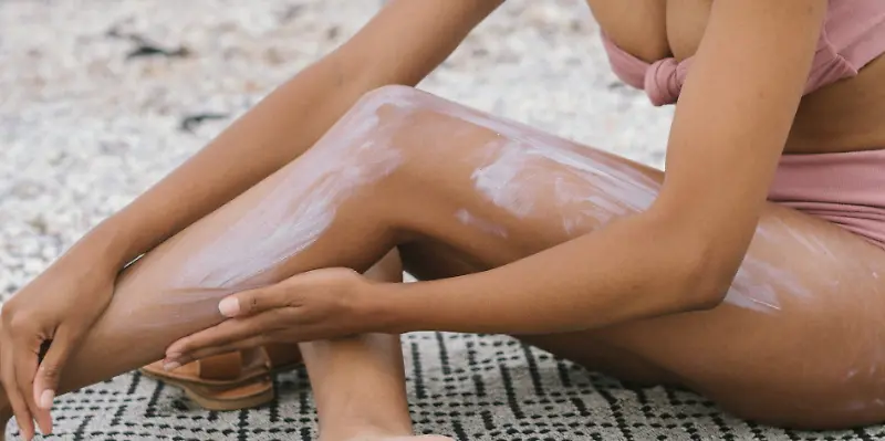 Sonnencreme, Strand, Frau cremt sich ein